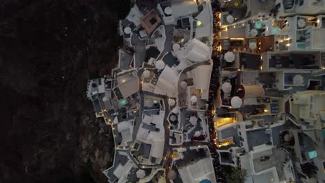 Aerial-Top-View-after-Sunset-over-Cliffside-of-Oia-Village,-Santorini,-Greece