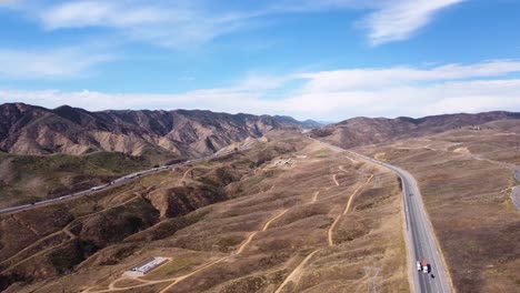 Drone-shot-of-roads-cutting-through-the-mountains-in-Santa-Clarita,-California