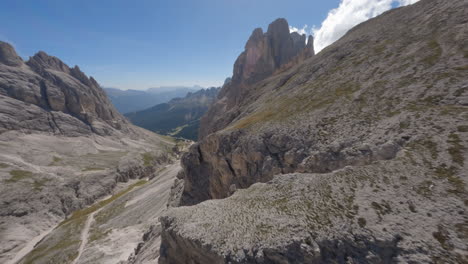 Drone-flying-over-rocky-ridge-of-mountain-peaks-in-summer-season,-Dolomites-in-Italy