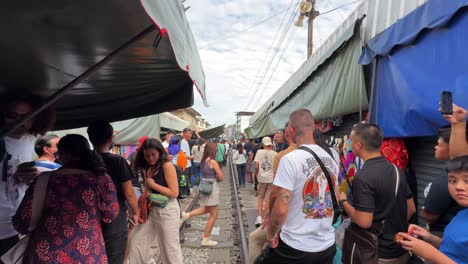 Touristischer-Maeklong-Eisenbahnmarkt-Talad-Rom-Hub-Vorbereitung-Zug-Vorbei