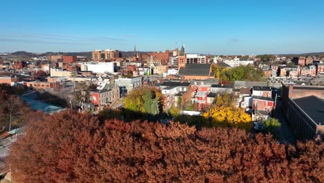 Colorful-autumn-trees-in-front-of-York,-Pennsylvania-skyline-on-bright-fall-day