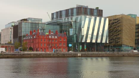 Moderne-Architektur-Am-Fluss-Liffey-In-Dublins-Silicon-Docks,-Reflektierende-Glasfassaden,-Bewölkter-Himmel