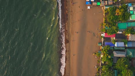 Relaxing-tourist-at-sandy-beach-in-front-of-bay-at-sunset