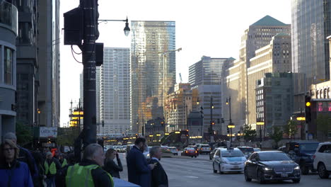 Medium-shot-of-busy-morning-traffic-with-pedestrians-in-downtown-Chicago-on-a-cloudy-day,-4K-handheld-slow-motion