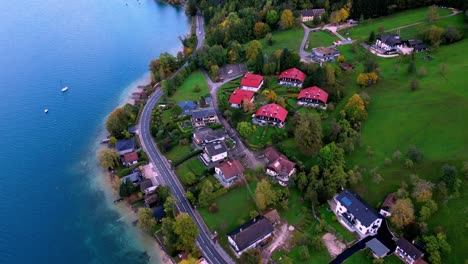 Friedliche-Luftaufnahme-Einer-Kleinen-Stadt-Am-Ufer-Eines-Glitzernden-Sees