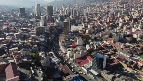 City-traffic-on-street-in-urban-cityscape,-aerial-over-Oruro,-Bolivia