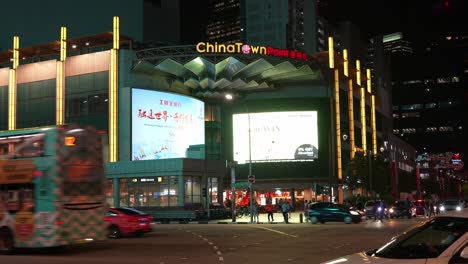 Static-shot-capturing-the-busy-night-traffics-at-the-junction-of-New-Bridge-Road-and-Upper-Cross-Street-featuring-landmark-Chinatown-Point-shopping-mall,-Singapore