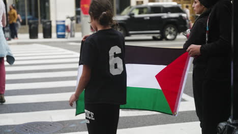 A-Girl-Holds-Up-a-Palestinian-Flag-at-a-Crosswalk-During-a-Free-Palestine-Protest-in-Washington-D