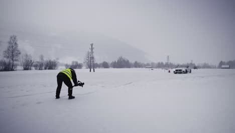 Person-Mit-Kamera-Trägt-Grüne-Sicherheitsweste-Beim-Winter-Drift-Wettbewerb