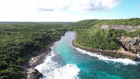 Turquoise-blue-river-flowing-through-the-jungle-in-Guadeloupe,-aerial-dolly-in