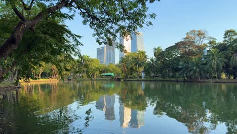 City-buildings-reflexion-clear-Lumpini-park-lake-water-Bangkok-Thailand