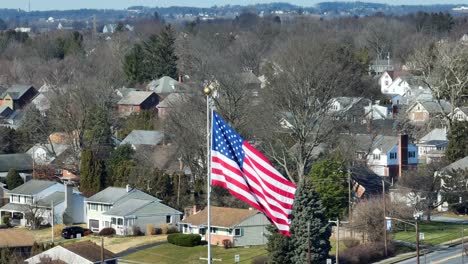 Waving-American-Flag-in-front-of-American-neighborhood