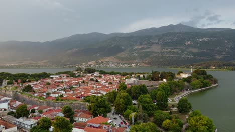 Ioannina-cityscape-and-beautiful-Lake-Pamvotida-in-Greece-with-mountain-background,-aerial-flyover