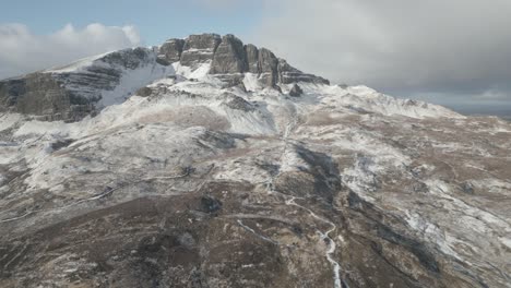 El-Anciano-De-Storr-Cubierto-De-Nieve-En-La-Isla-De-Skye,-Escocia,-Bajo-Un-Cielo-Nublado,-Vista-Aérea