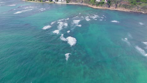 drone-footage-of-the-beautiful-aqua-water-tilting-up-to-reveal-Diamond-Head-volcanic-formation-on-the-island-of-Oahu-Hawaii-with-cityscape-of-Honolulu,-Hawaii-on-the-Horizon