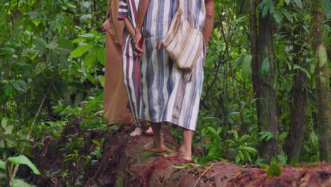 Barefoot-indigenous-people-walking-on-a-log-in-Oxapampa,-Peru,-in-traditional-clothing,-surrounded-by-lush-forest