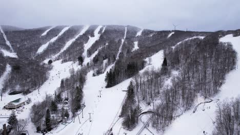 Ski-slopes-running-down-the-side-of-a-mountain-with-skiers-and-snowboarders