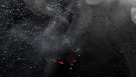 small-patch-of-steel-wool-burning-down-in-mezmerizing-patterns-on-black-rock-background