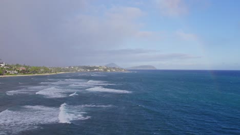 Luftaufnahmen-Der-Küste-Der-Insel-Oahu-Auf-Den-Hawaii-Inseln,-Die-Sich-Zurückziehen,-Um-Das-Leuchtend-Blaue-Wasser-Des-Pazifiks-Und-Die-Weißen-Schaumkronen-Der-Wellen-Zu-Enthüllen,-Die-Ans-Ufer-Rollen