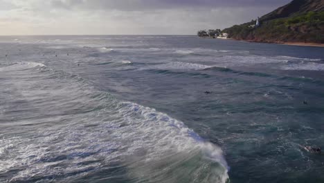 Luftaufnahmen-Von-Meereswellen-Und-Kiteboardern-Auf-Dem-Weg-Zum-Diamond-Head-Lighthouse-Auf-Der-Felsigen-Klippe-Auf-Der-Insel-Oahu,-Hawaii