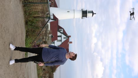 Content-Creator-Launching-Drone-From-Hand-With-Portland-Head-Lighthouse-In-The-Background