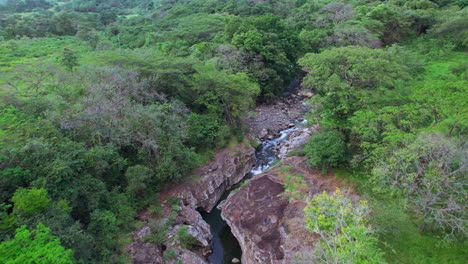 The-lush-cajones-de-chame-canyon-with-flowing-river-in-panama,-tranquil-nature-scene,-aerial-view