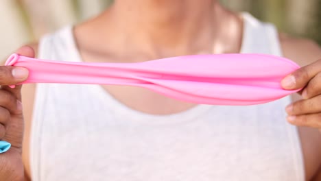 Unidentifiable-Person-Stretching-a-Big-Pink-Balloon-in-Close-up-Shot
