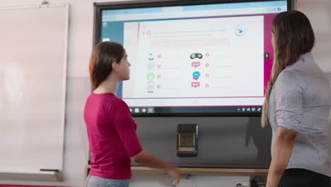 Bewegte-Aufnahme-Eines-Kaukasischen-Lehrers-Und-Schülers,-Die-Während-Des-Unterrichts-Einen-Großen-Touchscreen-Verwenden