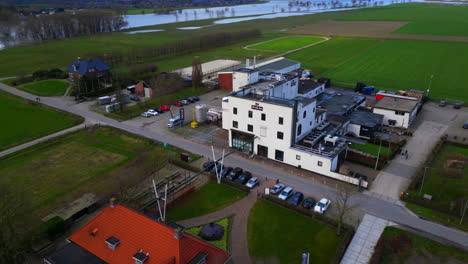 Orbit-aerial-around-Hertog-Jan-beer-brewery-on-the-Meuse-river-shore-Limburg
