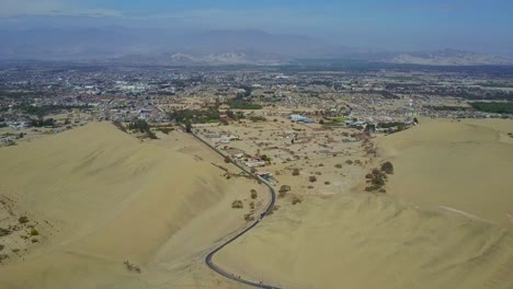 Stadt-Ica-In-Der-Nähe-Der-Oase-Huacachina-Mit-Straße,-Die-Zwischen-Sanddünen-In-Peru,-Südamerika-In-Die-Stadt-Führt