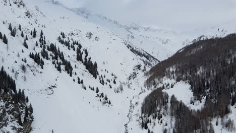 Cabins-sit-nestled-in-a-snow-covered-alpine-valley-in-the-Italian-Dolomites