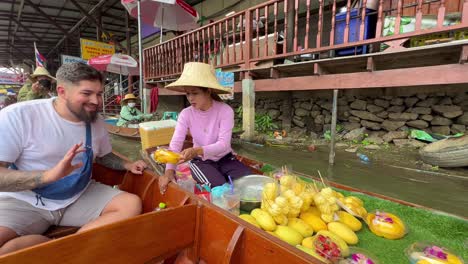 Tourist-negotiate-with-local-seller-at-floating-market-in-South-East-Asia