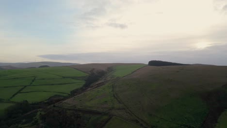 Low-level-drone-flight-over-farmland-and-forest-in-the-British-countryside