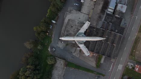 Top-Down-Aerial-View-of-Abandoned-Boeing-707-Airplane-on-Rooftop-of-Gowalt-Expo-Near-Wetteren,-Belgium