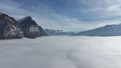 Cliffside-above-Sea-of-Fog-by-Walensee,-Switzerland---aerial