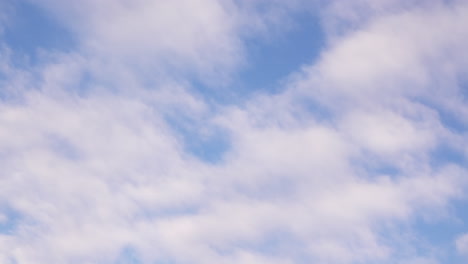 Time-lapse-footage-of-white-fluffy-winter-clouds-moving-across-the-blue-sky-on-a-sunny-day