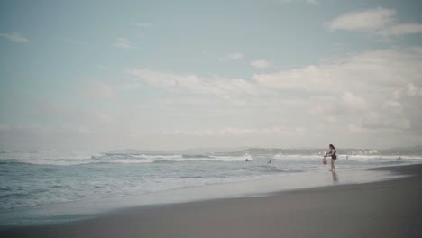 Mujer-De-Pie-En-Una-Playa-Mirando-Las-Olas-Del-Océano,-La-Union,-Filipinas