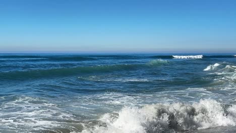 Olas-Del-Océano-Rompiendo-Y-Rociando-Juntas-Durante-La-Marea-Real-Sobre-El-Océano-Azul-Y-El-Cielo-Azul