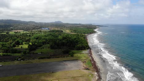 Pearls-airport-in-grenada,-showcasing-the-abandoned-runway-along-the-coast,-aerial-view