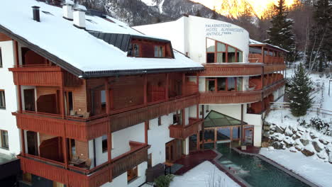Hotelgebäude-Inmitten-Einer-Atemberaubenden-Alpenlandschaft,-Bedeckt-Mit-Frisch-Gefallenem-Schnee