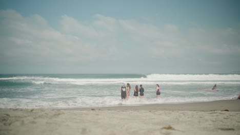 Grupo-De-Amigos-De-Pie-Las-Olas-Del-Mar-En-La-Playa-De-La-Unión-En-Filipinas