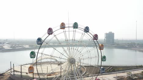 Rajkot-Atal-See-–-Drohnenansicht-–-Drohnenkamera-Bewegt-Sich-Nach-Oben,-Wo-Auch-Ein-Großer-See-Hinter-Dem-Riesenrad-Sichtbar-Ist,-Rajkots-Neue-Rennstrecke,-Atal-Sarovar