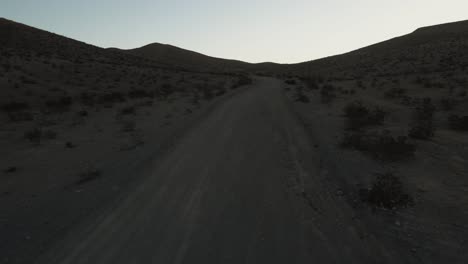 Imágenes-Aéreas-De-Un-Camino-Polvoriento-En-El-Desierto-Que-Conduce-A-Las-Colinas