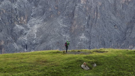 Photographer-taking-pictures-of-beautiful-rocky-Dolomites,-aerial-parallax-shot