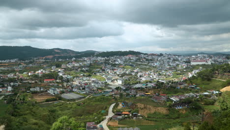 View-from-Cable-Car-Gondola-Window-on-Dalat-City-Dramatic-Skyline-on-Cloudy-Day,-Vietnam---Aerial-View