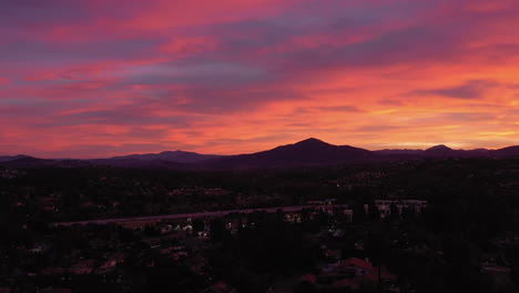 Drone-panning-shot-over-homes-in-Chula-Vista-and-highway-54-during-vibrant-sunrise