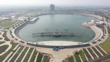 Vista-Desde-Un-Dron-Del-Lago-Rajkot-Atal-Cámara-De-Un-Dron-Avanzando-Donde-También-Se-Ven-Un-Gran-Lago-Y-Muchas-Aves-Y-El-Agua-Brilla-Con-Los-Rayos-Del-Sol