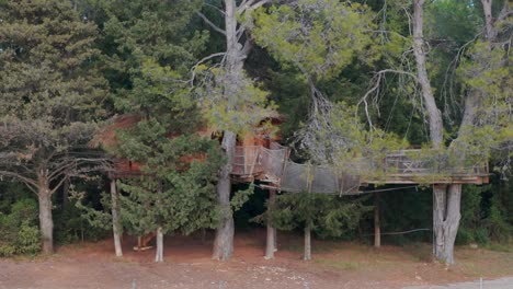 Aerial-rotating-view-of-Wooden-tree-house-concept-in-Domaine-St-Jean-de-l'Arbousier