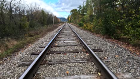 Train-Tracks-In-A-Beautiful-Fall-Forest-Landscape,-FPV-Aerial-Flyover