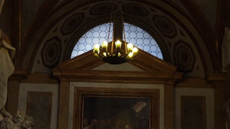 Glowing-light-from-hanging-candelabra-in-Catholic-Church-of-Gesu-Nuovo,